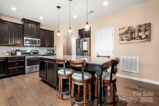 2262 Galloway Ln SW, Concord, NC 28025 - kitchen with a kitchen island, wood finished floors, visible vents, and appliances with stainless steel finishes