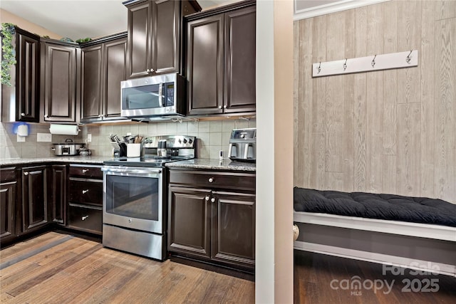 2262 Galloway Ln SW, Concord, NC 28025 - kitchen featuring light stone counters, decorative backsplash, appliances with stainless steel finishes, and wood finished floors