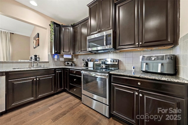 2262 Galloway Ln SW, Concord, NC 28025 - kitchen with wood finished floors, light stone countertops, stainless steel appliances, and a sink