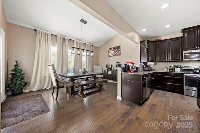 2262 Galloway Ln SW, Concord, NC 28025 - kitchen with lofted ceiling, dark brown cabinetry, appliances with stainless steel finishes, and dark wood-style flooring