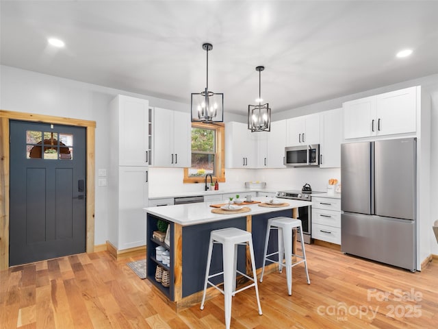 282 County Rd, Waynesville, NC 28785 - kitchen featuring a kitchen bar, white cabinetry, a kitchen island, light countertops, and stainless steel appliances