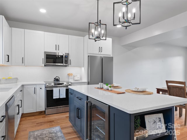 282 County Rd, Waynesville, NC 28785 - kitchen with light wood-type flooring, white cabinetry, open shelves, wine cooler, and appliances with stainless steel finishes