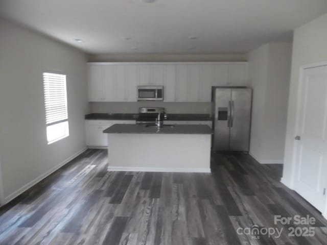 574 30th Avenue Cir NE, Hickory, NC 28601 - kitchen featuring appliances with stainless steel finishes, dark countertops, white cabinets, dark wood finished floors, and a sink