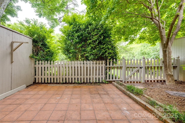 view of patio featuring fence, an outbuilding, and a shed