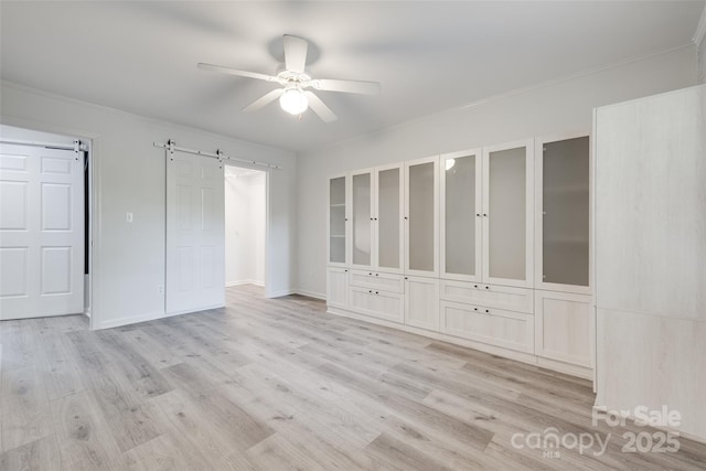 5901 Quail Hollow Rd Unit G, Charlotte, NC 28210 - unfurnished bedroom with a barn door, light wood-style floors, ornamental molding, ceiling fan, and baseboards