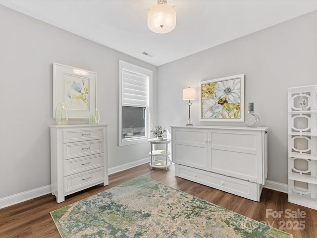 bedroom with visible vents, dark wood finished floors, and baseboards