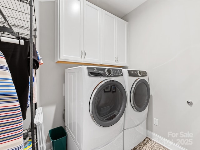clothes washing area with separate washer and dryer, cabinet space, and baseboards