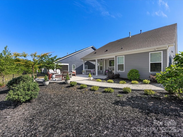 rear view of property with fence and a patio area