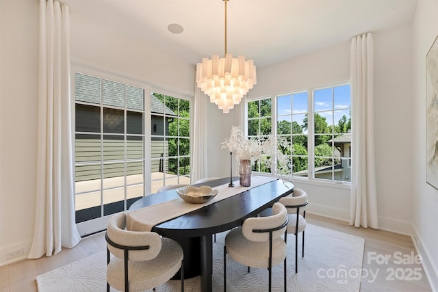 3473 Willow Oak Rd, Charlotte, NC 28209 - dining room with baseboards, light wood-style flooring, and a chandelier