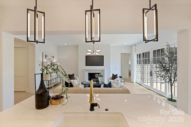 3473 Willow Oak Rd, Charlotte, NC 28209 - kitchen with pendant lighting, light stone countertops, a fireplace, and open floor plan