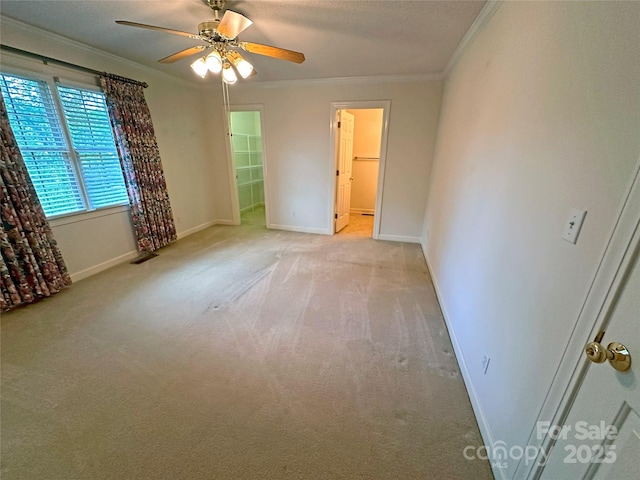 904 3rd Street Pl NE, Conover, NC 28613 - unfurnished bedroom featuring a walk in closet, a ceiling fan, light colored carpet, baseboards, and ornamental molding