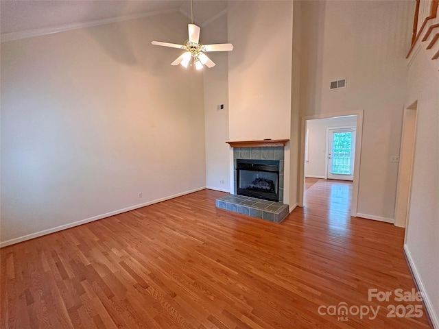904 3rd Street Pl NE, Conover, NC 28613 - unfurnished living room with visible vents, wood finished floors, baseboards, high vaulted ceiling, and a tile fireplace
