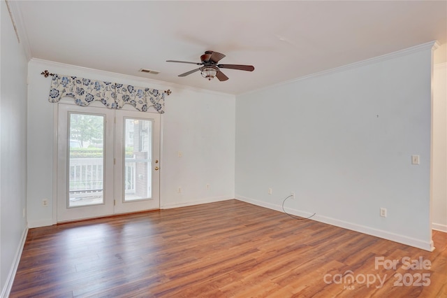 unfurnished room with ornamental molding, a ceiling fan, wood finished floors, and visible vents