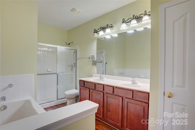 full bathroom featuring a bath, a shower stall, double vanity, and a sink