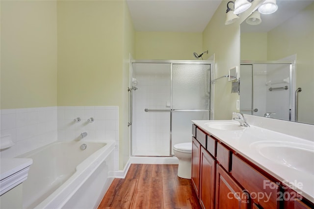 full bath with a bath, a shower stall, wood finished floors, and a sink