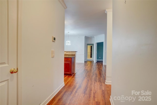 hallway with baseboards and wood finished floors