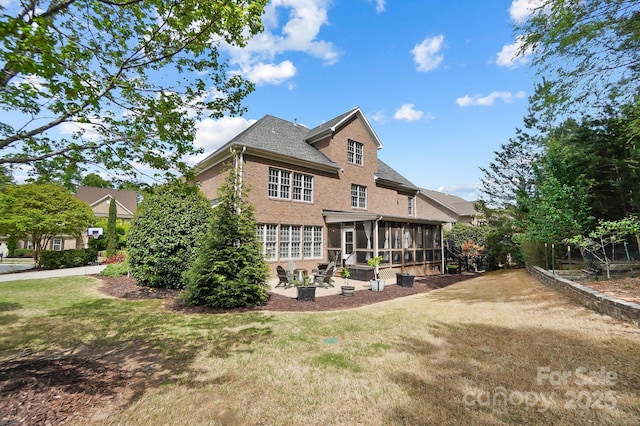 16532 Flintrock Falls Ln, Charlotte, NC 28278 - back of property with brick siding, a sunroom, a patio, and a lawn