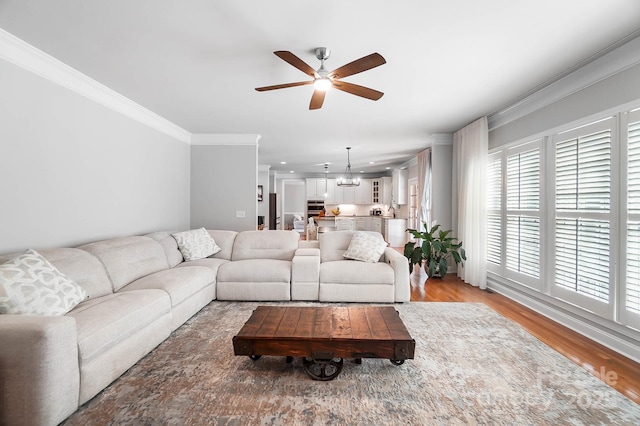 16532 Flintrock Falls Ln, Charlotte, NC 28278 - living room featuring ornamental molding, a healthy amount of sunlight, light wood-style floors, and ceiling fan with notable chandelier