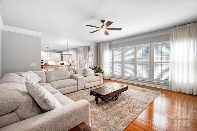 16532 Flintrock Falls Ln, Charlotte, NC 28278 - living room featuring a wealth of natural light, ornamental molding, light wood finished floors, and ceiling fan with notable chandelier