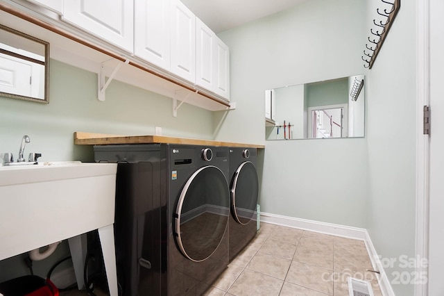 16532 Flintrock Falls Ln, Charlotte, NC 28278 - laundry room with light tile patterned flooring, cabinet space, baseboards, visible vents, and independent washer and dryer