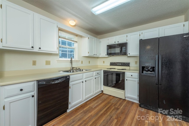 3101 Idle Hour Dr, Asheville, NC 28806 - kitchen featuring black appliances, dark wood-style flooring, light countertops, white cabinetry, and a textured ceiling