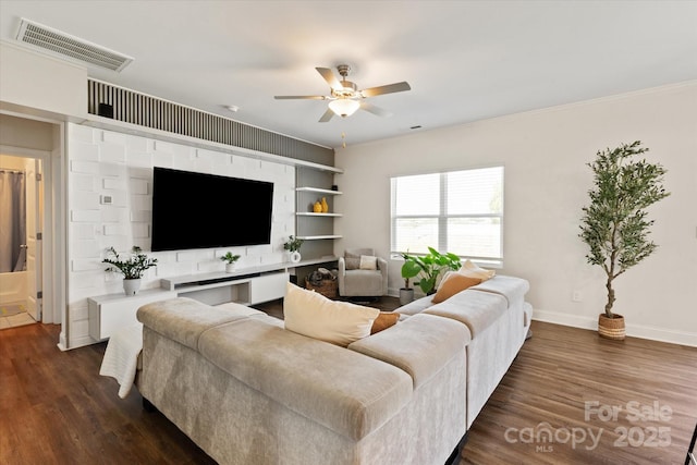 living area featuring ceiling fan, dark wood-type flooring, crown molding, visible vents, and baseboards