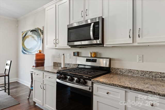 kitchen featuring baseboards, stainless steel appliances, ornamental molding, white cabinetry, and dark wood-style floors