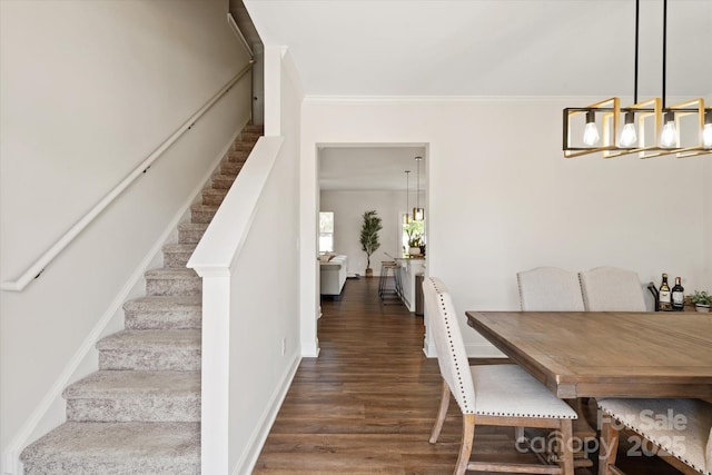dining area with wood finished floors, a notable chandelier, stairs, and crown molding
