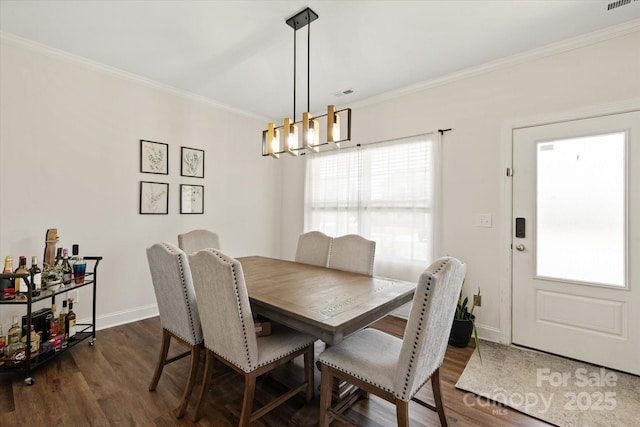 dining space with dark wood-type flooring, a chandelier, and ornamental molding