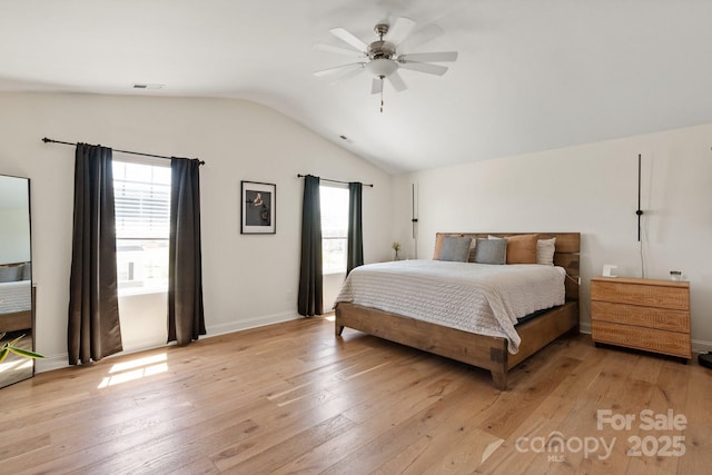 bedroom with lofted ceiling, light wood finished floors, and multiple windows