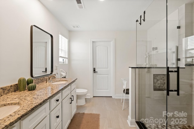 bathroom with a shower stall, a sink, double vanity, visible vents, and toilet