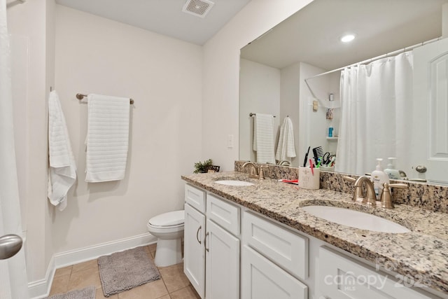 bathroom featuring visible vents, toilet, baseboards, and a sink