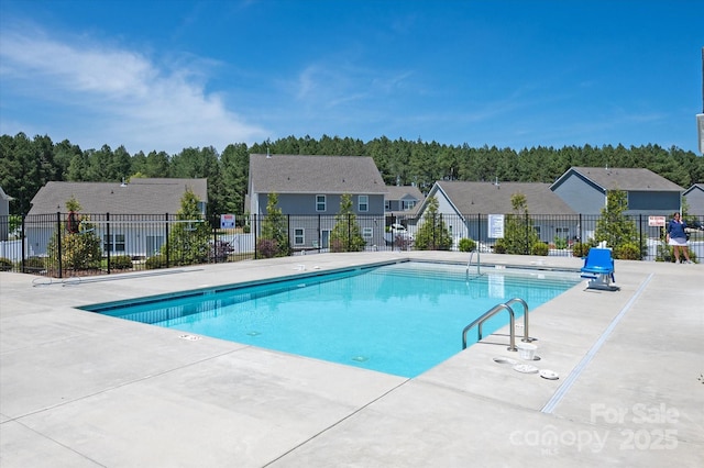 pool featuring a patio, fence, and a residential view