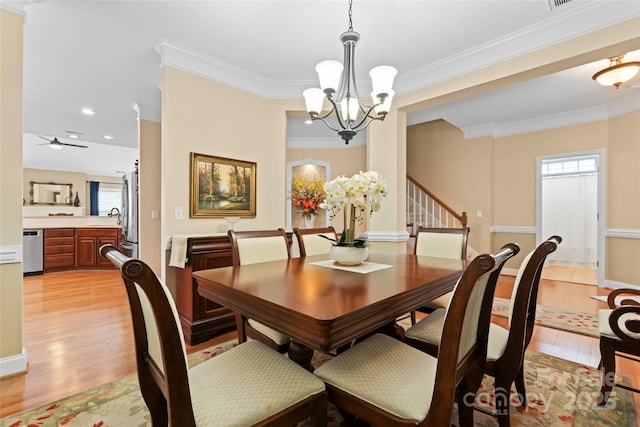 dining space featuring crown molding, ceiling fan with notable chandelier, light wood-type flooring, and plenty of natural light