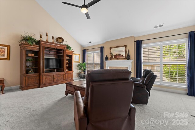 living room with light colored carpet, a ceiling fan, visible vents, and a fireplace