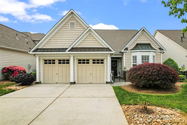 craftsman house with a garage, driveway, a shingled roof, metal roof, and a standing seam roof