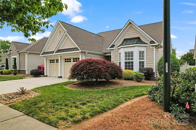 craftsman inspired home with a shingled roof, a front lawn, concrete driveway, a standing seam roof, and a garage