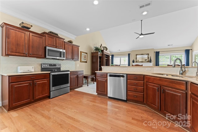 kitchen featuring a sink, light wood-type flooring, light countertops, appliances with stainless steel finishes, and visible vents