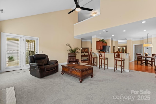 living room with recessed lighting, ornamental molding, light colored carpet, high vaulted ceiling, and ceiling fan