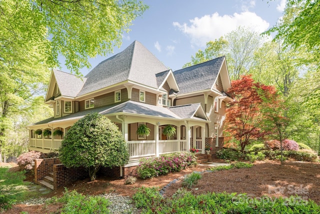 view of property exterior featuring a porch and a shingled roof