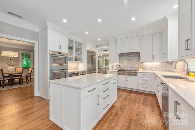 kitchen featuring white cabinetry, stainless steel appliances, and a sink
