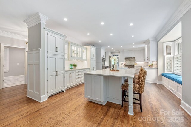 kitchen with white cabinets, light countertops, recessed lighting, and ornamental molding