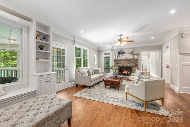 living area featuring recessed lighting, light wood-style flooring, a fireplace, and a ceiling fan
