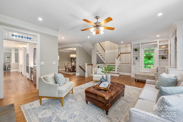 living room with light wood-style floors, recessed lighting, stairs, and crown molding