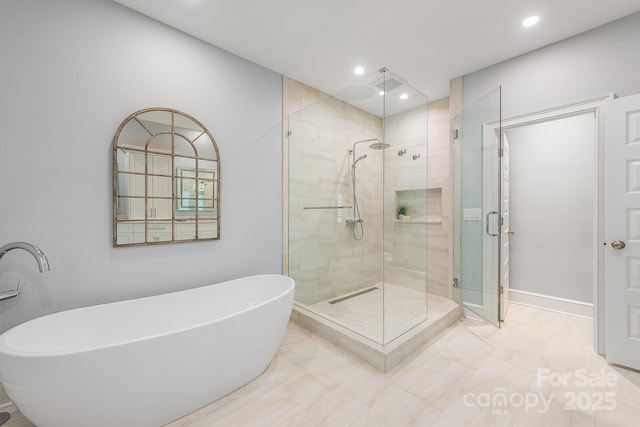 bathroom featuring recessed lighting, a shower stall, a soaking tub, and baseboards