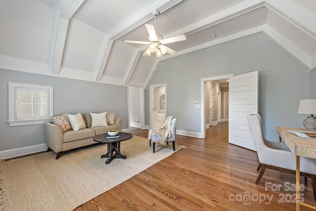 living area featuring baseboards, vaulted ceiling with beams, wood finished floors, and ceiling fan