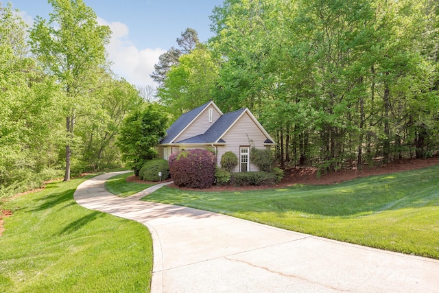 view of side of home with a lawn and driveway