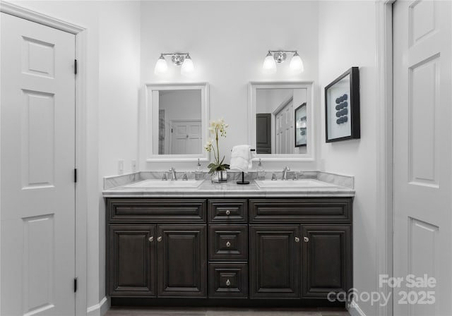 full bathroom featuring double vanity and baseboards