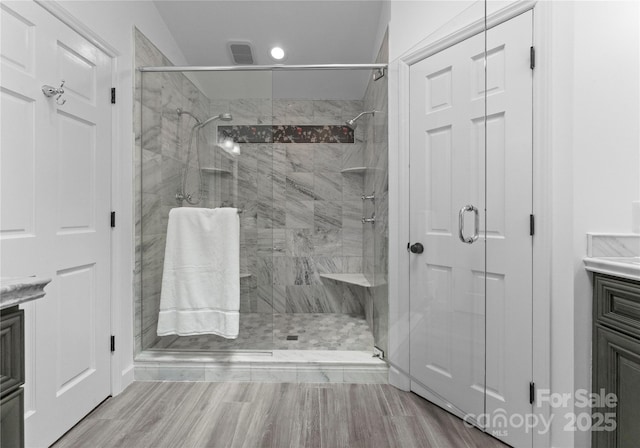 full bath with vanity, a stall shower, recessed lighting, and wood finished floors