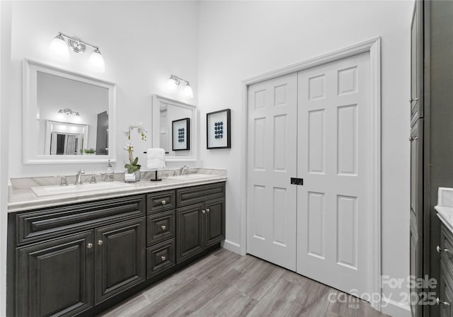 full bath featuring double vanity and wood finished floors